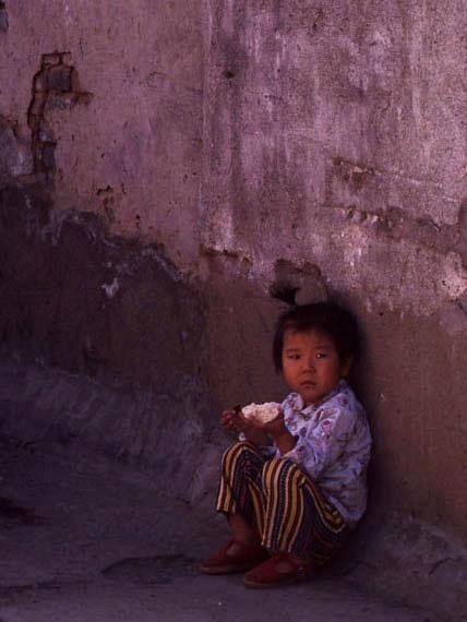 Chinese child eating in alley