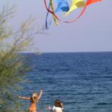 Girls dodge and chase kites