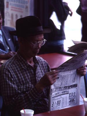 Chinese man reading, L.A.,Chinatown