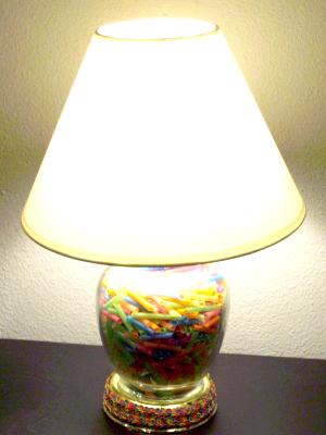 Reclaimed lamp filled with pieces of colorful straws.