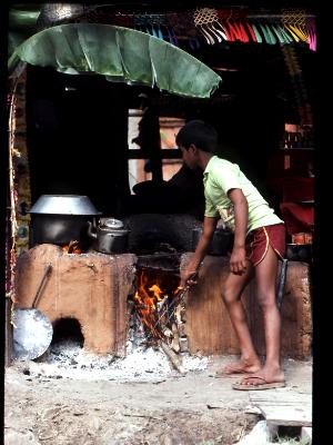 Nepalese boy stoking fire