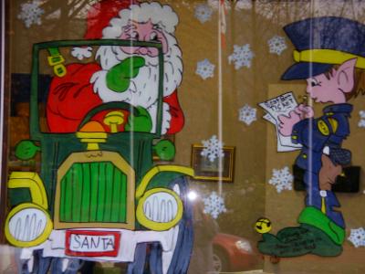 Santa in car getting seatbelt ticket from elf police.