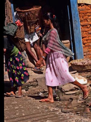 Nepalese girl crossing puddle