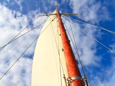 Schooner mast and sail in blue sky Schooner mast and sail in blue sky
